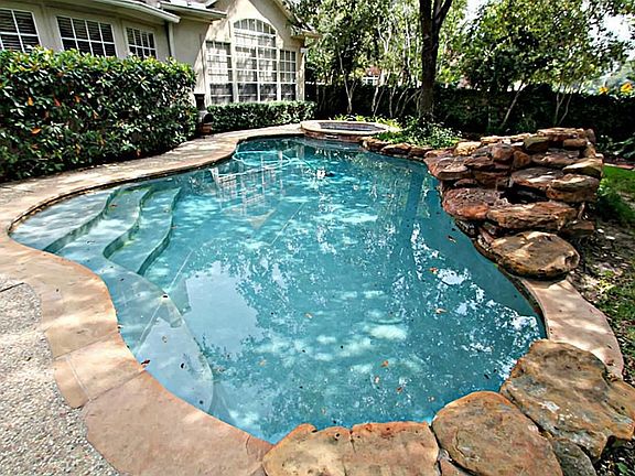 TAKE A VACATION IN YOUR OWN BACKYARD BOASTING A GLISTENING POOL AND SPA