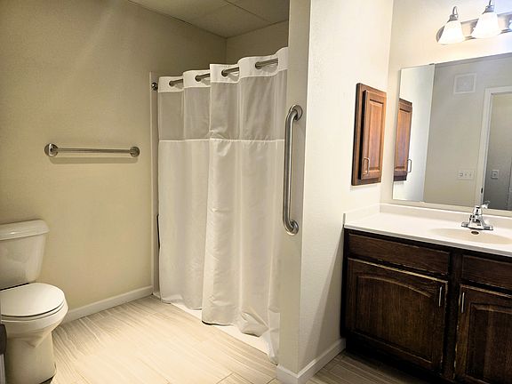 The bathroom features a walk-in shower with folding bench seat.