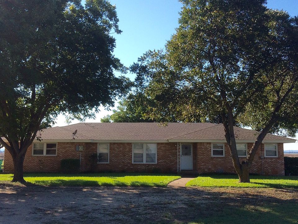 Country home with large yard and many trees.