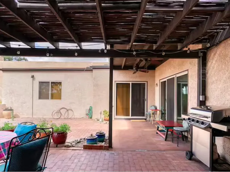 Gas grill for your use, and comfy cushioned chairs and table for al fresco dining, including overhead lights for the evenings
