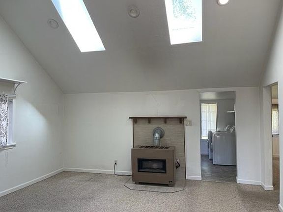 Living room with skylights and vaulted ceilings.