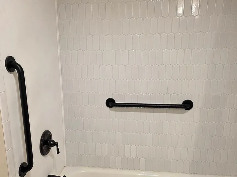 The first floor bathtub enclosure is equipped with two safety grab bars.