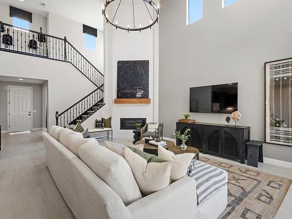 Gathering room and corner fireplace with large, bright windows plus elegant stair railing to the sec