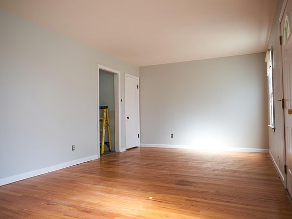 Spacious front room with fresh paint and polished wood floor