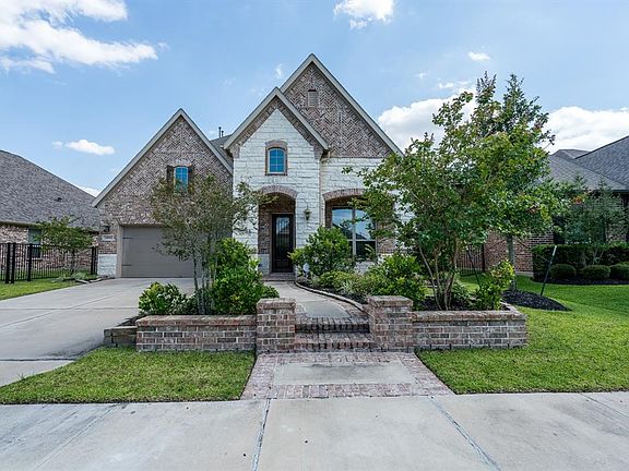Energy Star Certified home with brick and stone elevation, brick lined walkway, and arched covered front entry.