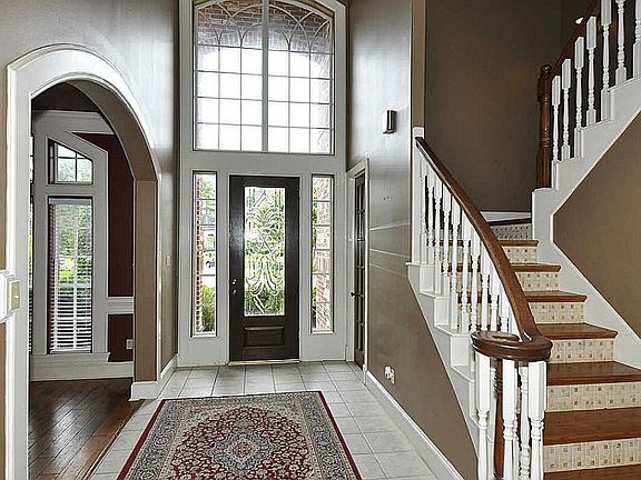 Bright two story foyer with tile floor. Notice curved architectural accents throughout the entire fi