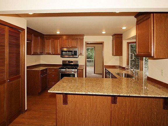 Slab granite countertops, stainless steel sink and applicances, pantry, hardwood floor. Cabinetry is