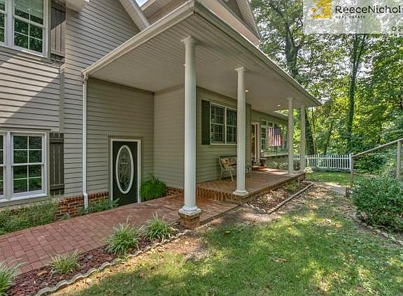 Cozy covered front porch nestled in the woods.