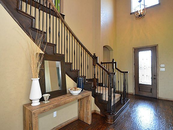 Upgraded wood floors match so eloquently with the wrought iron staircase.