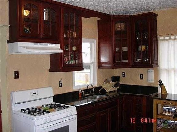 Kitchen with black granite counters and cherry cabinets