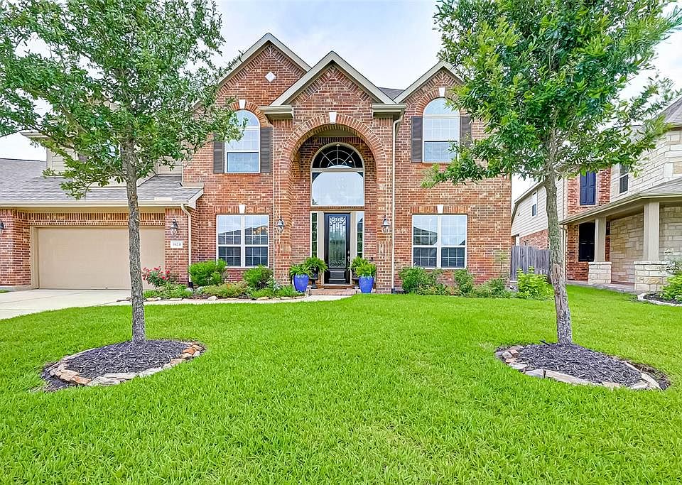 Welcoming, tall entry and perfect landscaping.