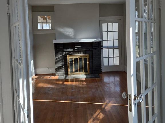 French doors from dining room to living room, hardwoods, fireplace, door to side porch.