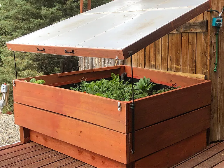 Owner designed and built Super Size GroBox in front of the house. Would you believe, it has a Queen size waterbed underneath it? And you don't have to bend way over to garden. Water harvesting from the roof is delivered by timer and tank.