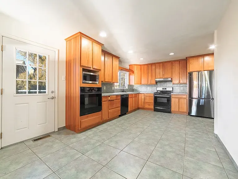 The spacious kitchen features two ovens, lots of cabinet storage, and two large pantries. The adjoining dining room includes an open breakfast nook overlooking the kitchen & den. A convenient second side-yard entrance provides easy access to the driveway.