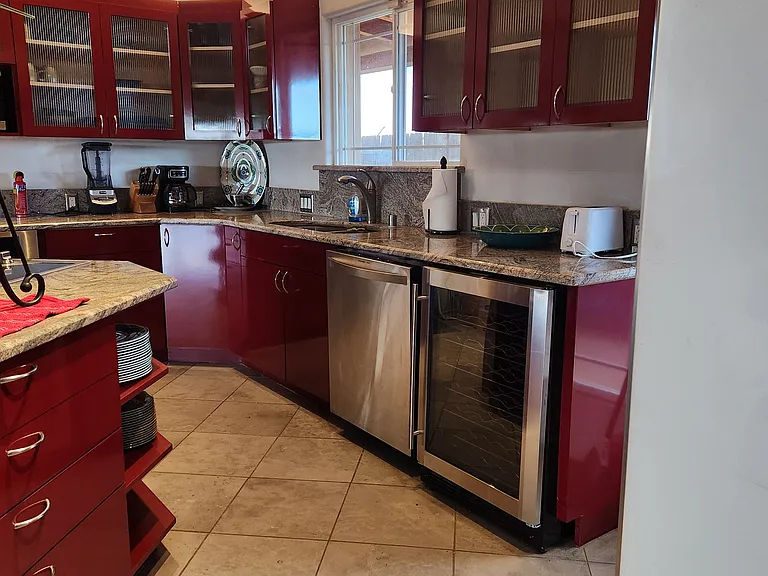 The kitchen from between the breakfast bar and the refrigerator.