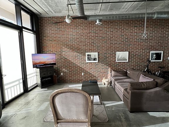 Pull down shades for the main living area; raw concrete floors and ceiling give NY loft vibes, plus exposed ductwork throughout.
