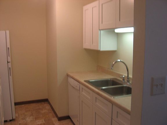 apartment for rent has dark brown cabinets.