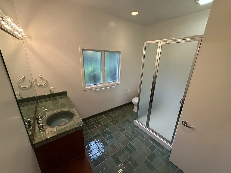 The pool bathroom are tastefully appointed with glass shower enclosures and organized storage.