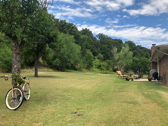 Backyard in the summer. Home backs to mountain-side for great privacy! 2 entrances on the back. Front yard has main entry and 2 fenced areas with a small porch.