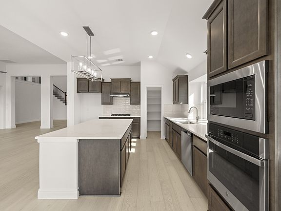 Sandstone II floor plan featuring a main-level primary suite, open-concept living, private study, an