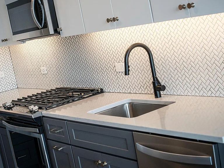 Marlowe Apartments Chicago Kitchen Details Tiled Backsplash, Blue Cabinets with Silver and Brass Hardware