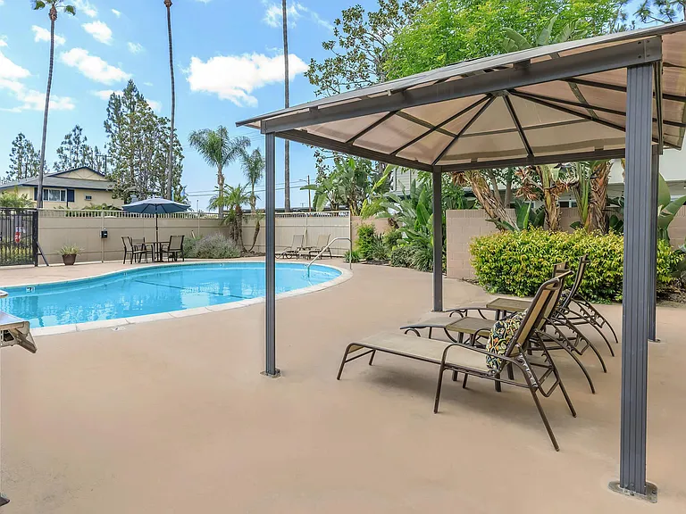 Second swimming pool with BBQ grill, lounge chairs and tables.