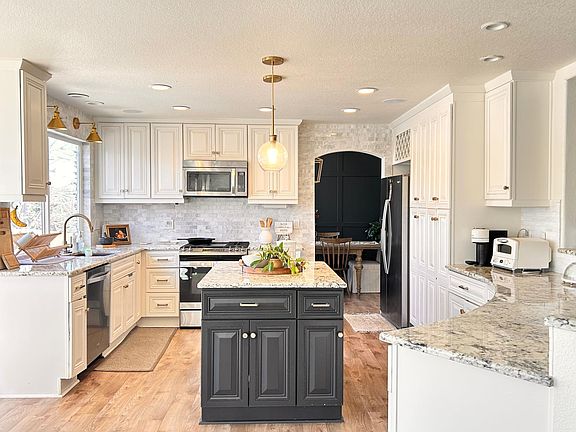 Granite countertops, custom painted kitchen, with stainless steel appliances.