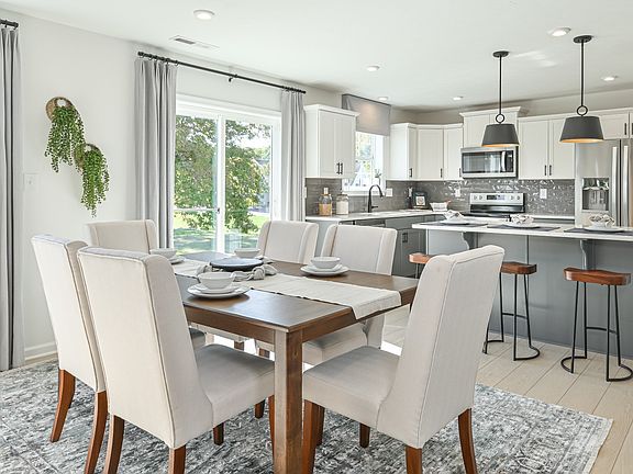 Open dining area with sliding glass door and stunning island kitchen with window above sink and gray
