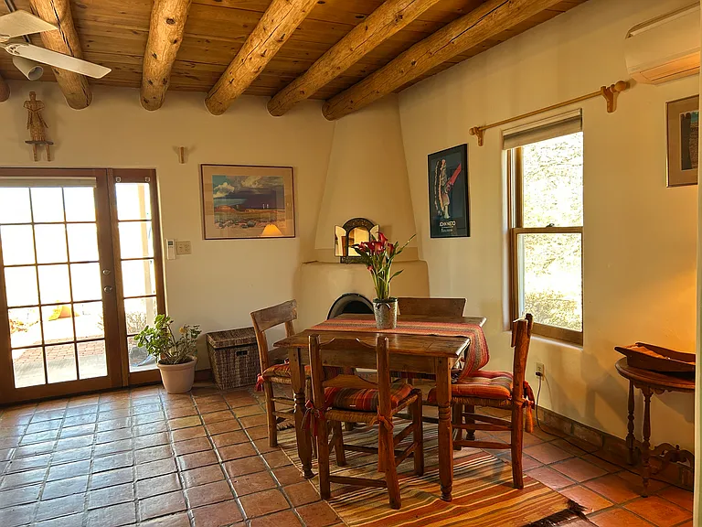 Dining area of the Nambe Casita with kiva wood burning fireplace. This is the view looking out towards the walled patio.