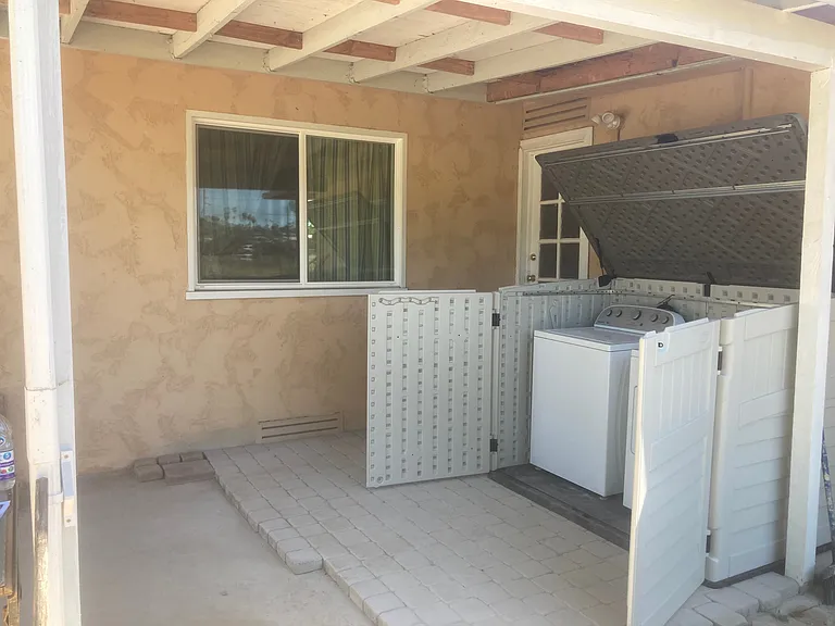 Covered patio with washer and dryer contained in a storage container