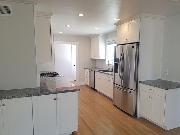 Kitchen with granite countertops and new Samsung stainless steel appliances.