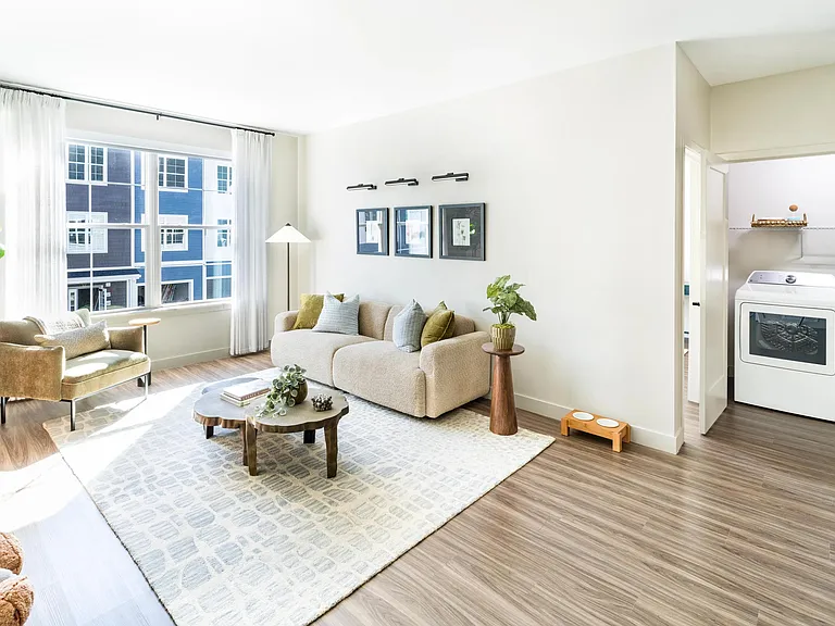 Natural light pours into this serene living space, complete with in-home laundry and warm coastal textures at Modera South Shore.