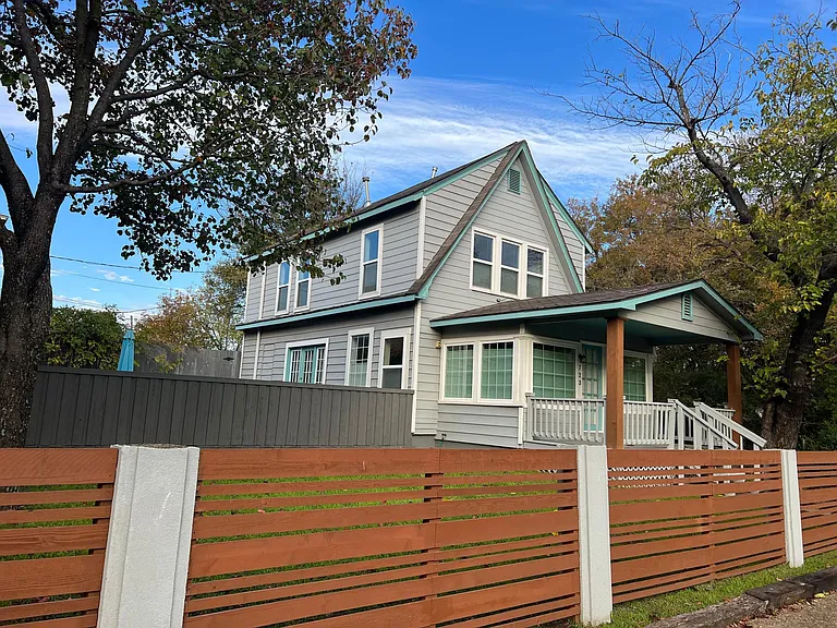 Street view of property with privacy fence, creating a nice buffer from the street and then privacy for the courtyard.
