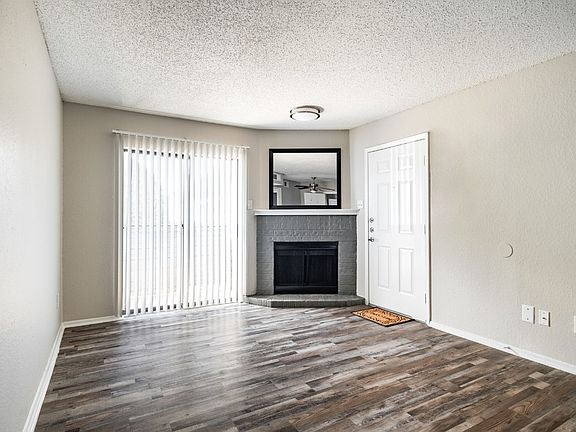 Open living area with fireplace and hardwood flooring with easy access to patio.