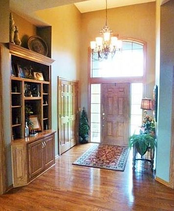 Front door entry has gorgeous heavy wood door, large entry close
