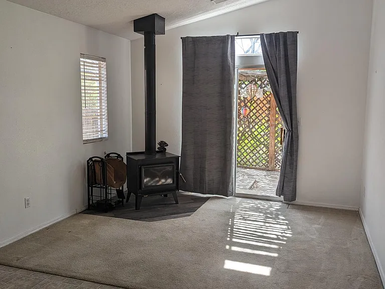 Dining area and carpeted family room right off the kitchen with a wood burning stove