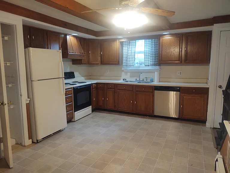 Large Eat-In Country Kitchen with tons of cabinets, dishwasher, stove, & refrigerator.