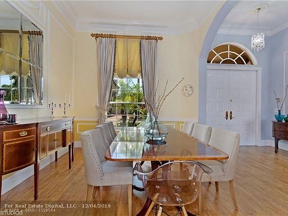 Formal dining room connected to kitchen with double crown molding and chair rail.