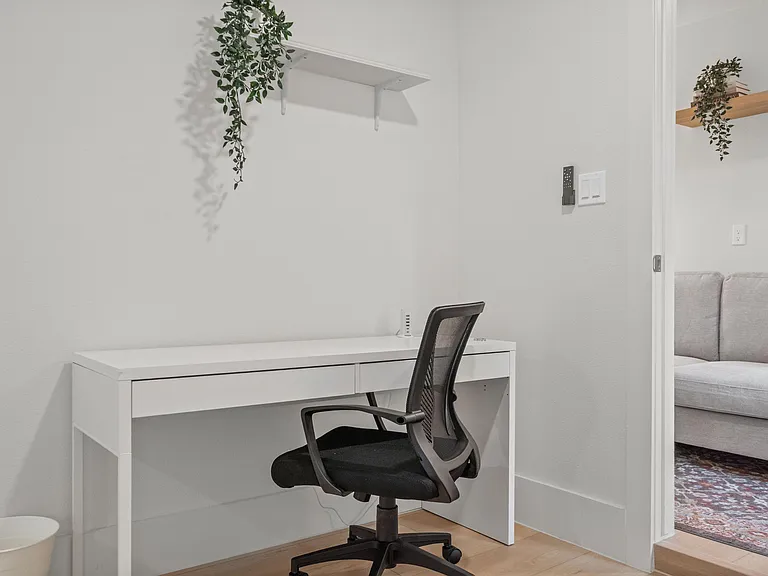 Dedicated desk nook with built-in shelving, offering a comfortable work-from-home setup off the main living area.
