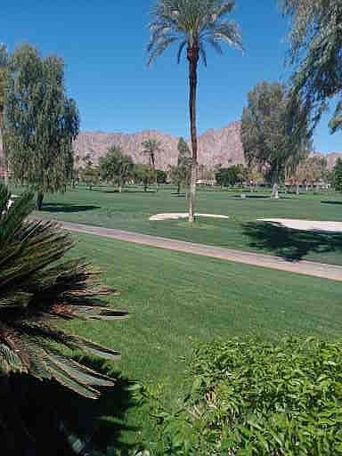 view from patio, endless green grass holes 1, 2, 8, 9,10,18 with trees and mountains. right on 1st hole of LA QUINTA C.C. Golf course.