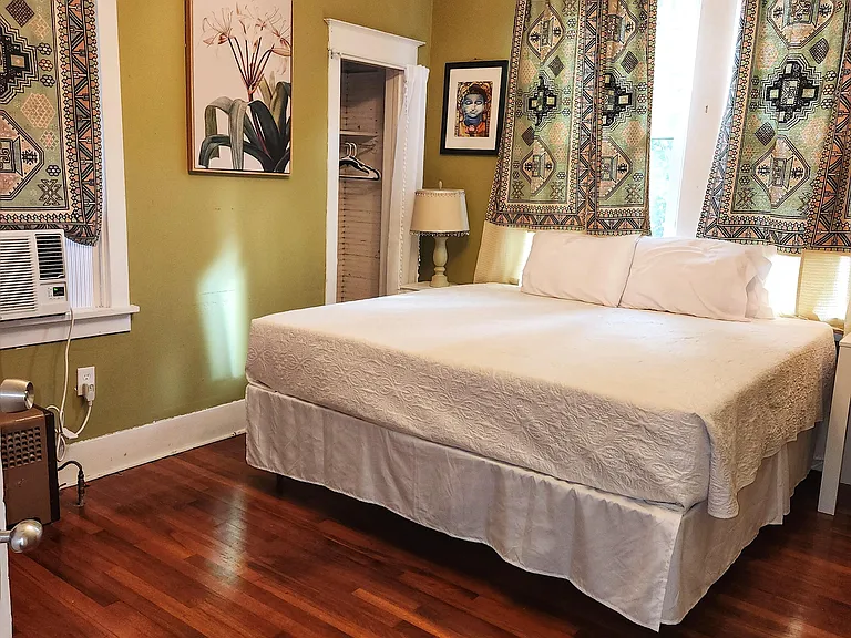 Green room. Courtyard view with 3 windows, King bed, wood floor, window AC/Heat unit, dedicated work station and TV