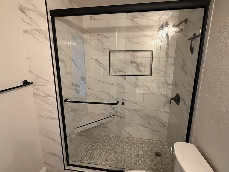 Remodeled guest bathroom with bench in shower