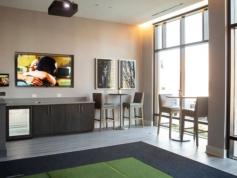 Lobby Area with High-Top Tables, Seating, and Wall-Mounted TV