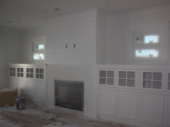 Den is large with wonderful view of backyard and pecan tree (or think pool!).  Shiplap top cap above fireplace and a wooden stained beam will be installed as mantel..