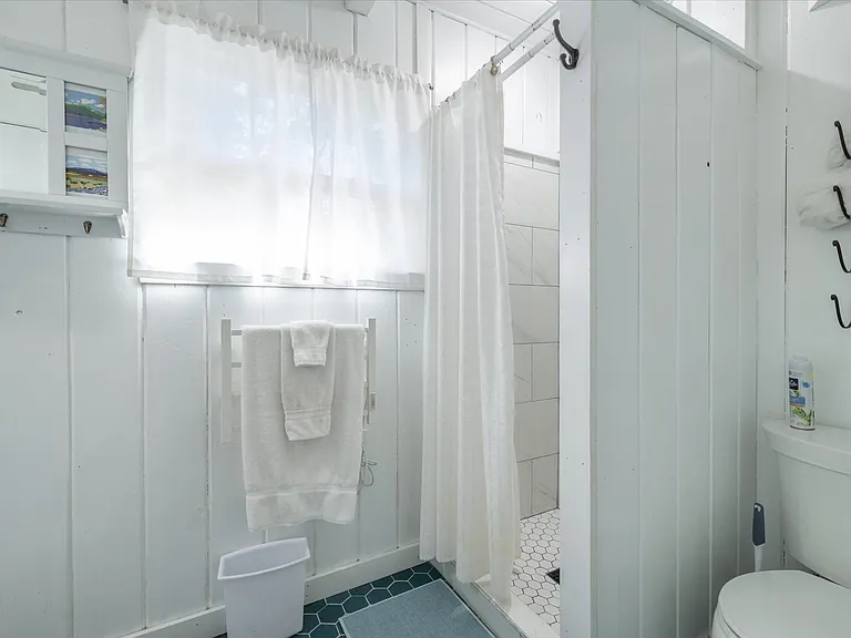 Bathroom with walk-in shower / shares space with washer / dryer.
