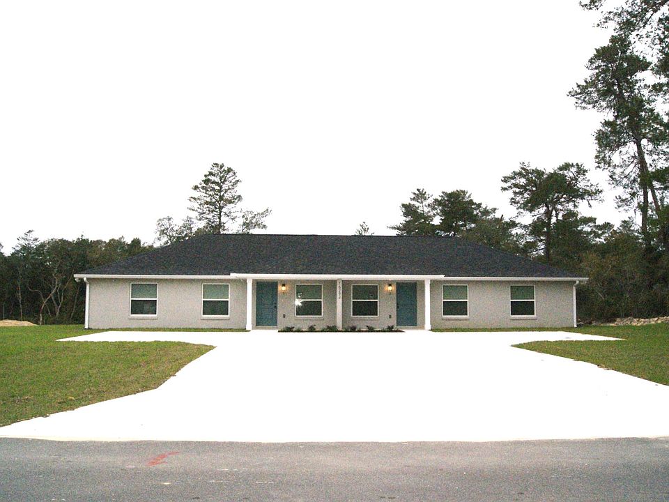 Front of duplex with large parking lot