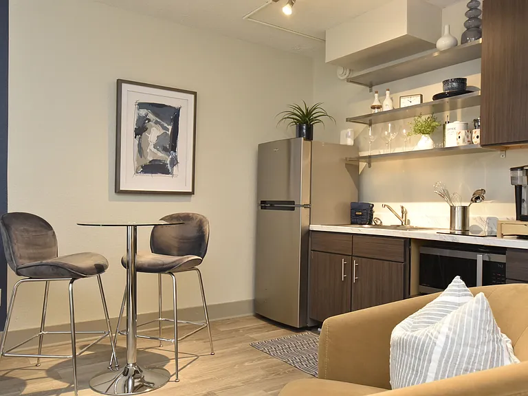 Kitchen with hardwood-style flooring, quartz counters and stainless appliances