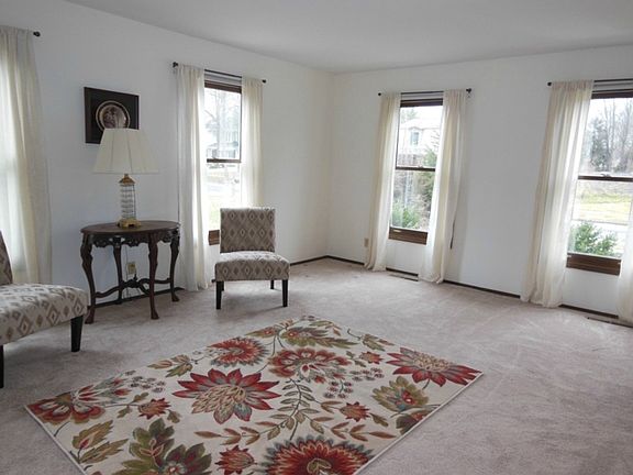 Formal living room with lots of windows and new carpeting.