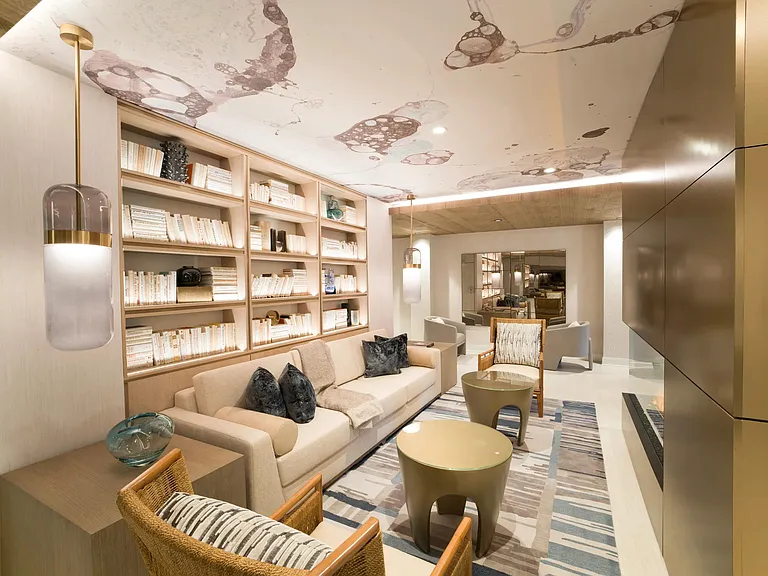 A refined resident lounge with built-in shelving, layered textures, and a fireplace backdrop for relaxed moments at Modera Liberty Row.