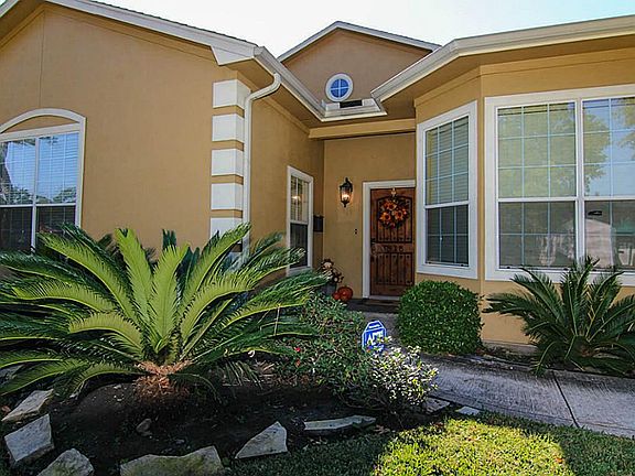 Gorgeous stucco exterior with nice landscaping and an elegant wood front door.